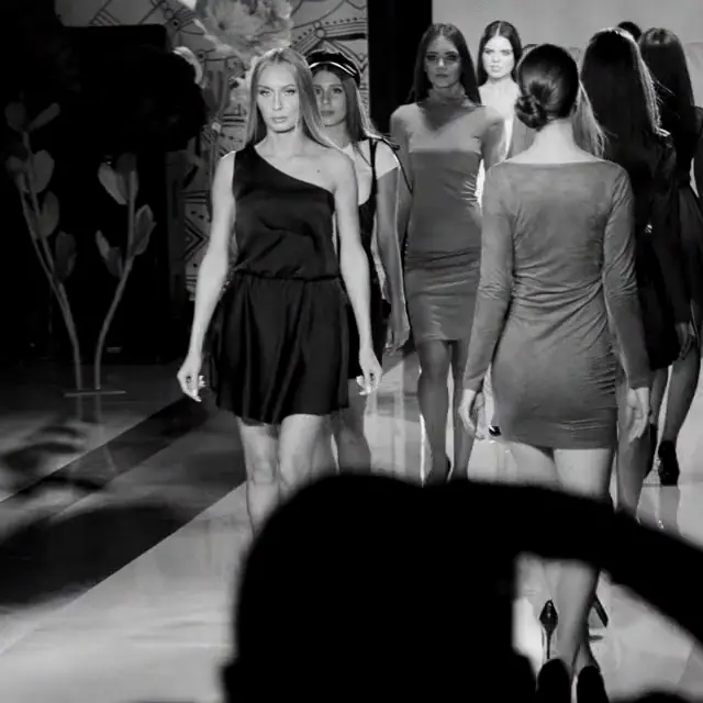 Black and white casting runway footage with talent moving through real backstage light